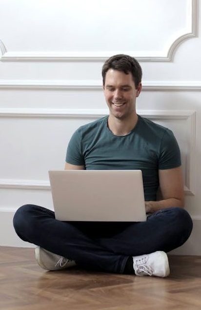 man in green crew neck t shirt using laptop